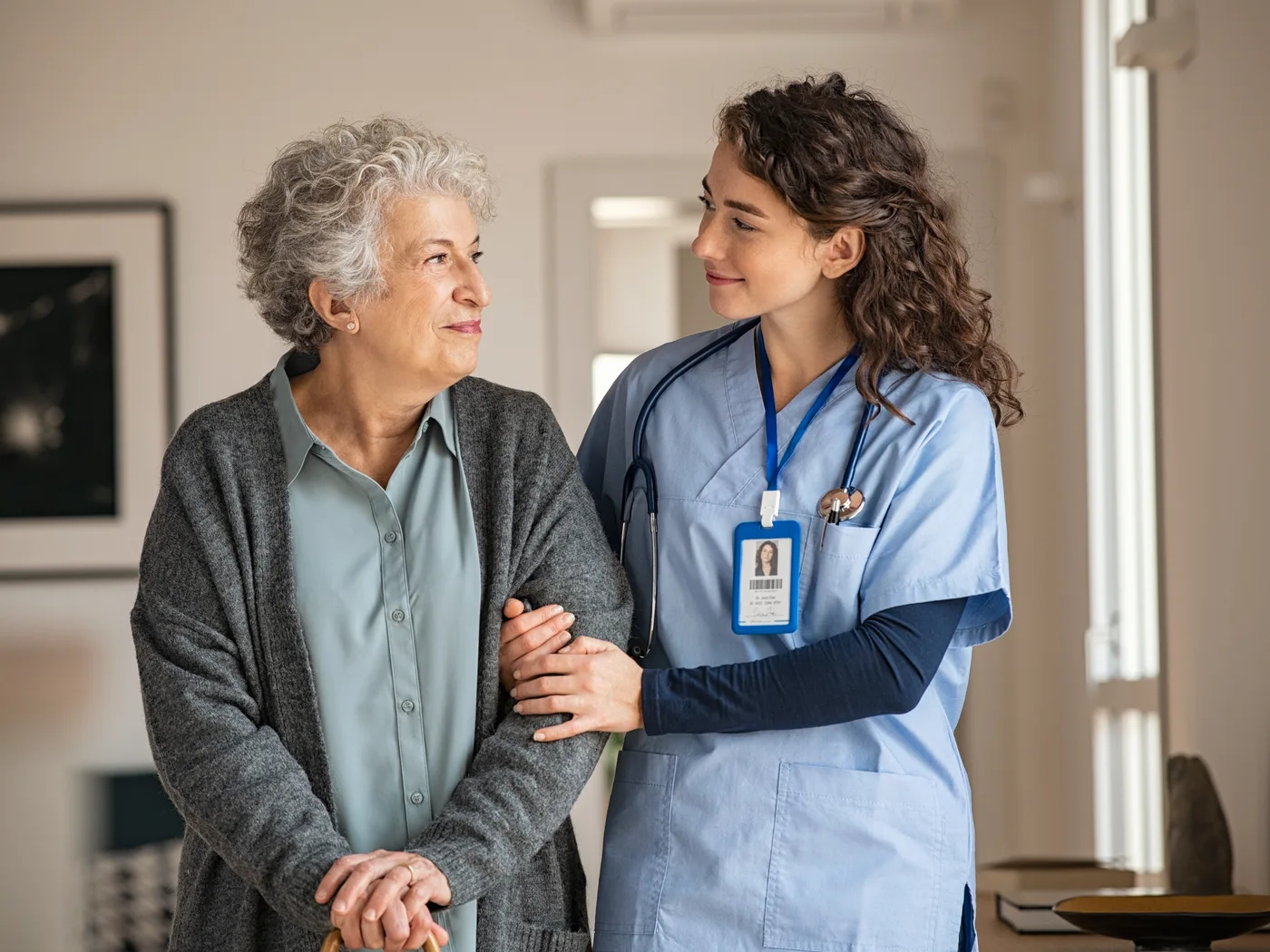 A caregiver walking arm in arm with an older patient
