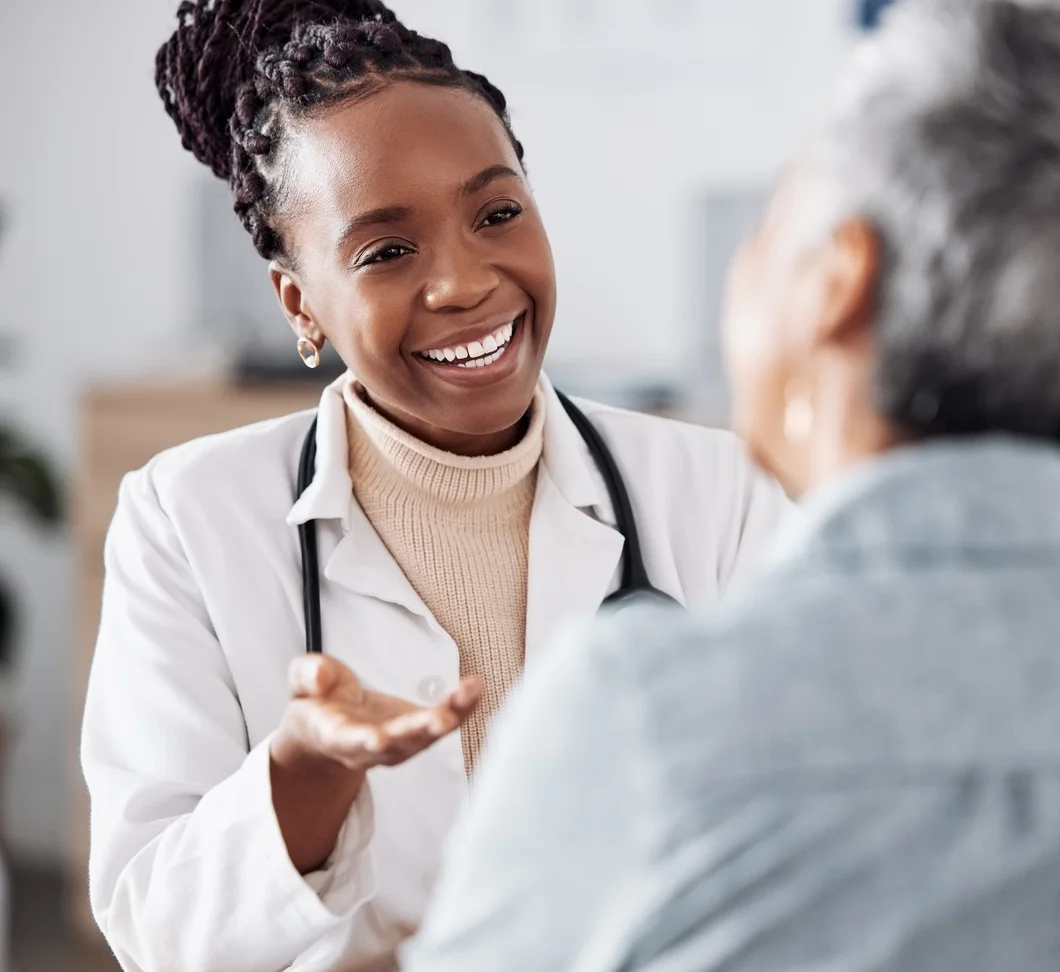 A smiling physician in conversation with her patient