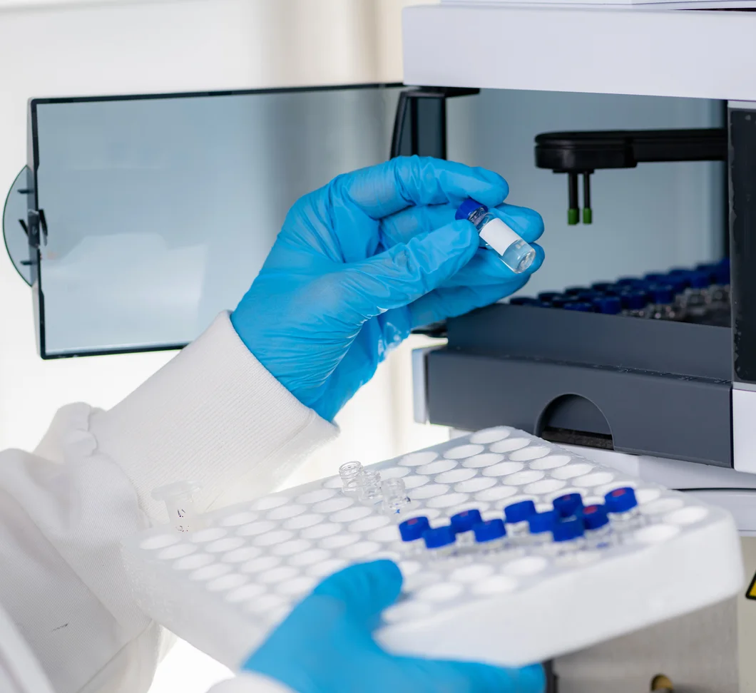 A lab technician loading sample vials into an analyzer